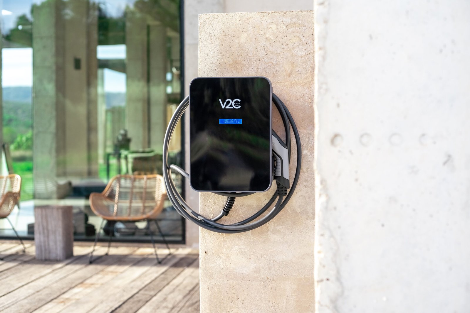 Borne de recharge V2C Trydan installée sur la façade d’une maison